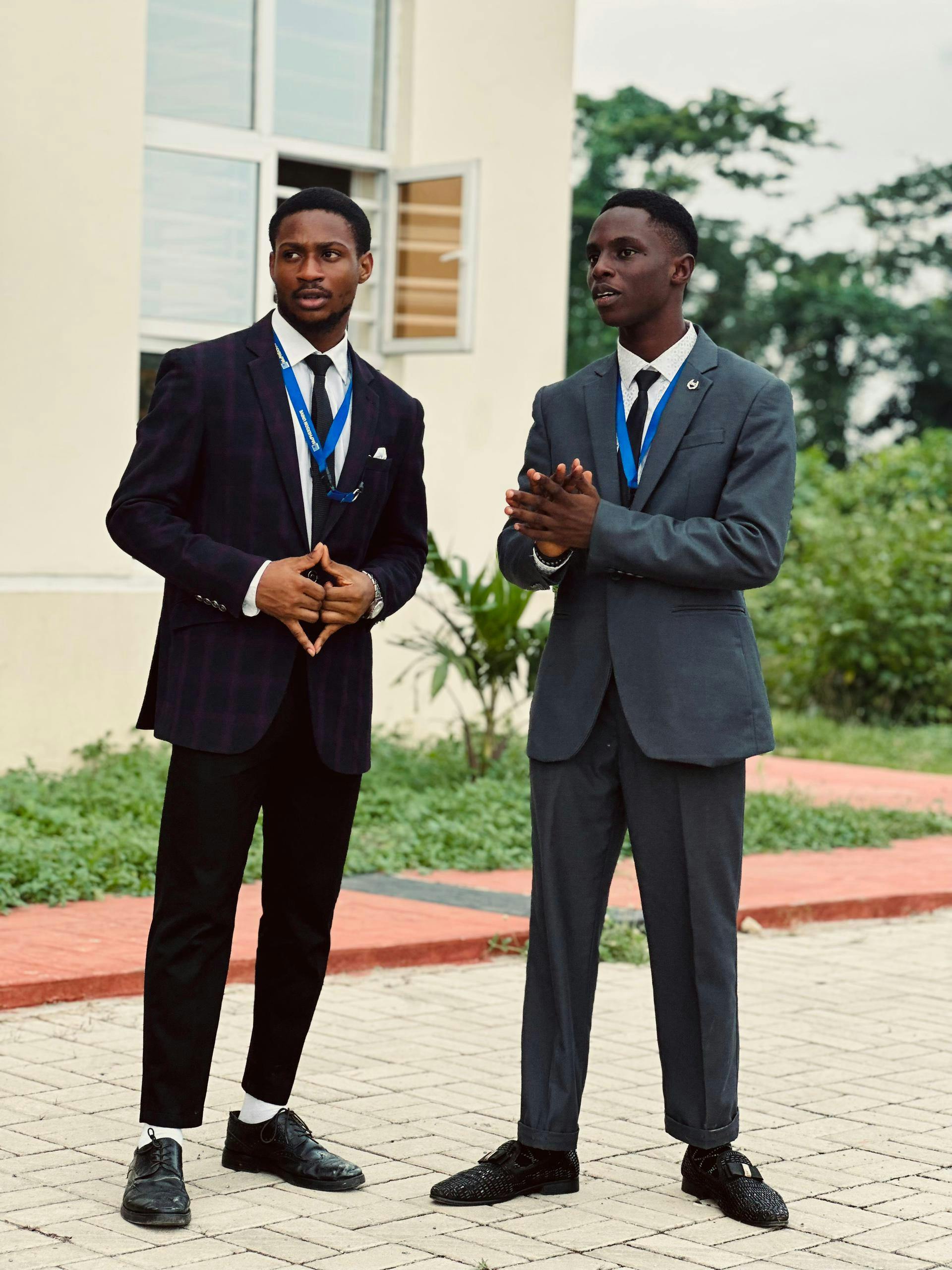 Two young men in formal suits standing outside during a conference in Seriki Sotayo, Ogun State.